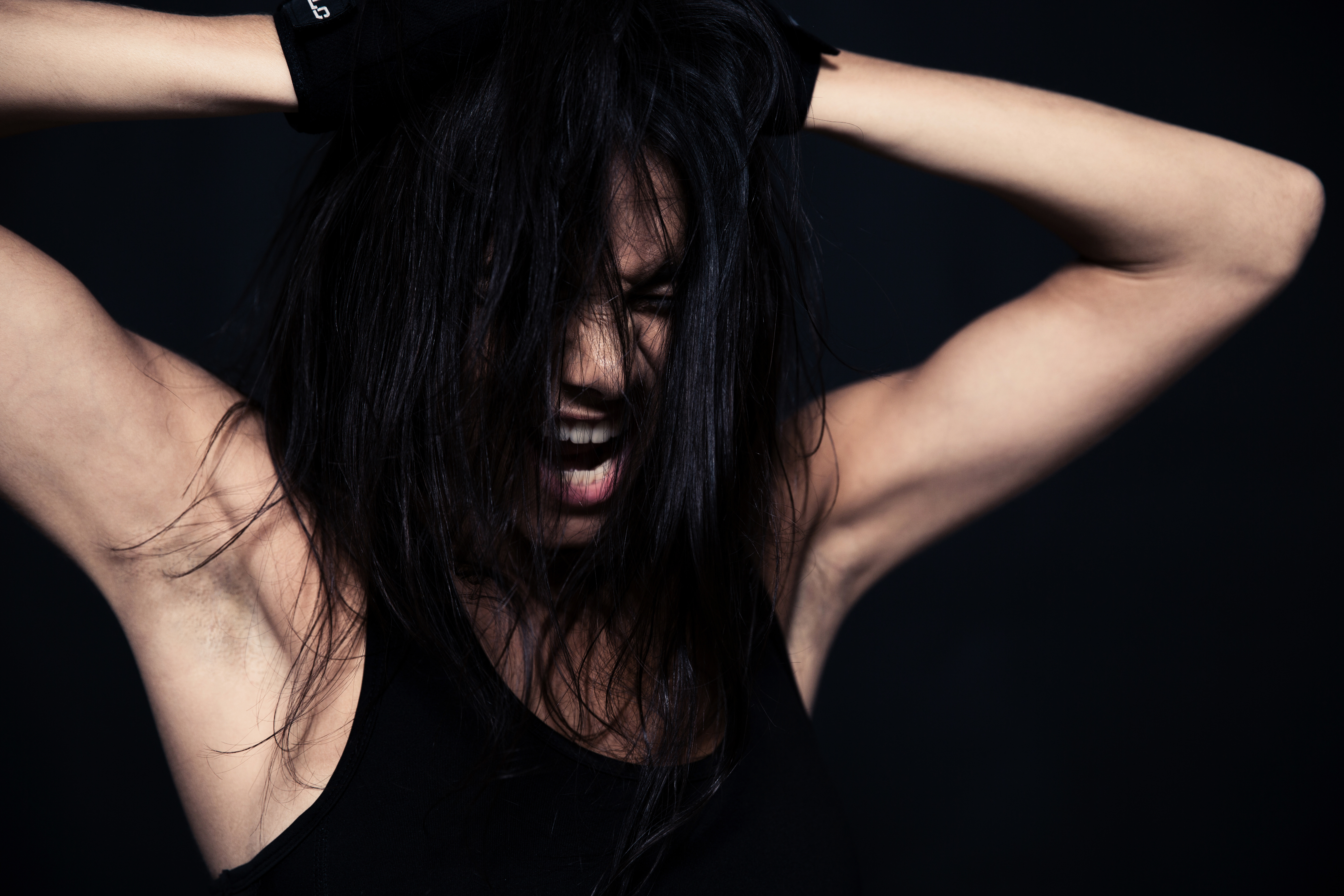 portrait of a fitness woman screaming over black background SBI 301026216